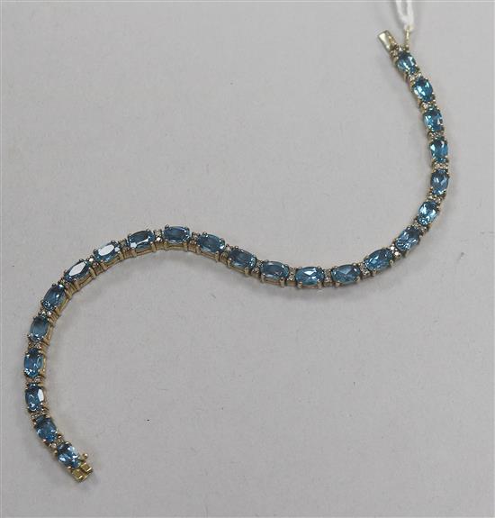 A 9ct gold, blue zircon and diamond chip set line bracelet, 18cm.